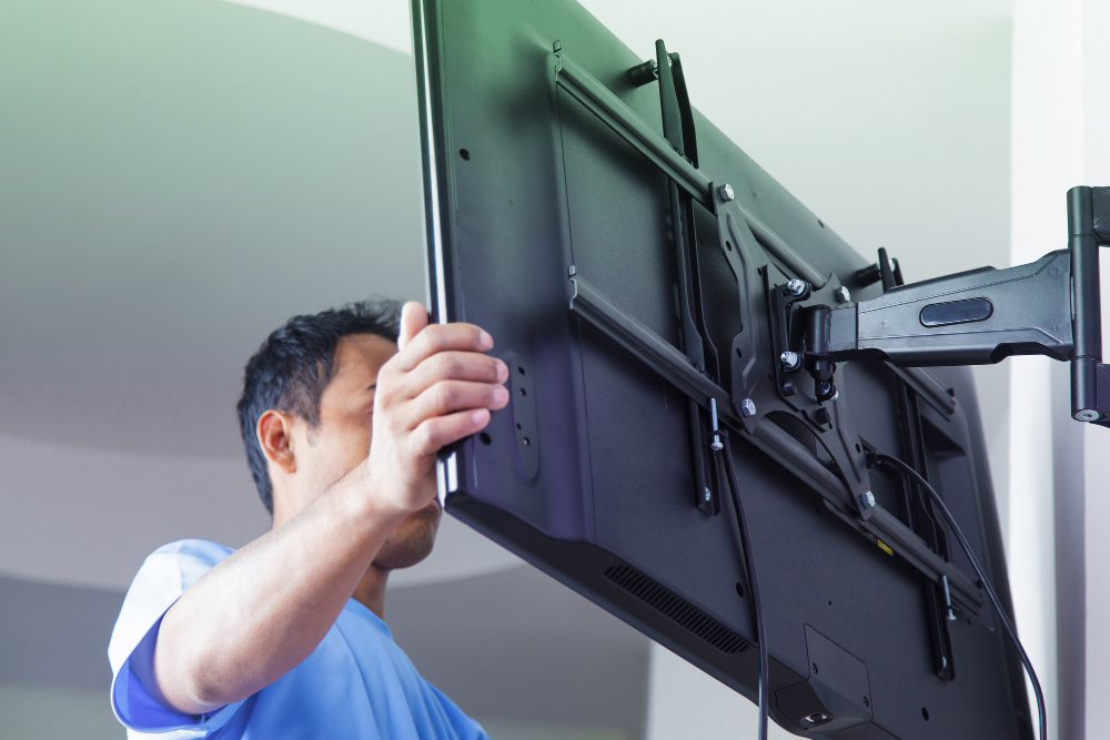 Move & Care technician mounting a TV in an Austin high-rise living room