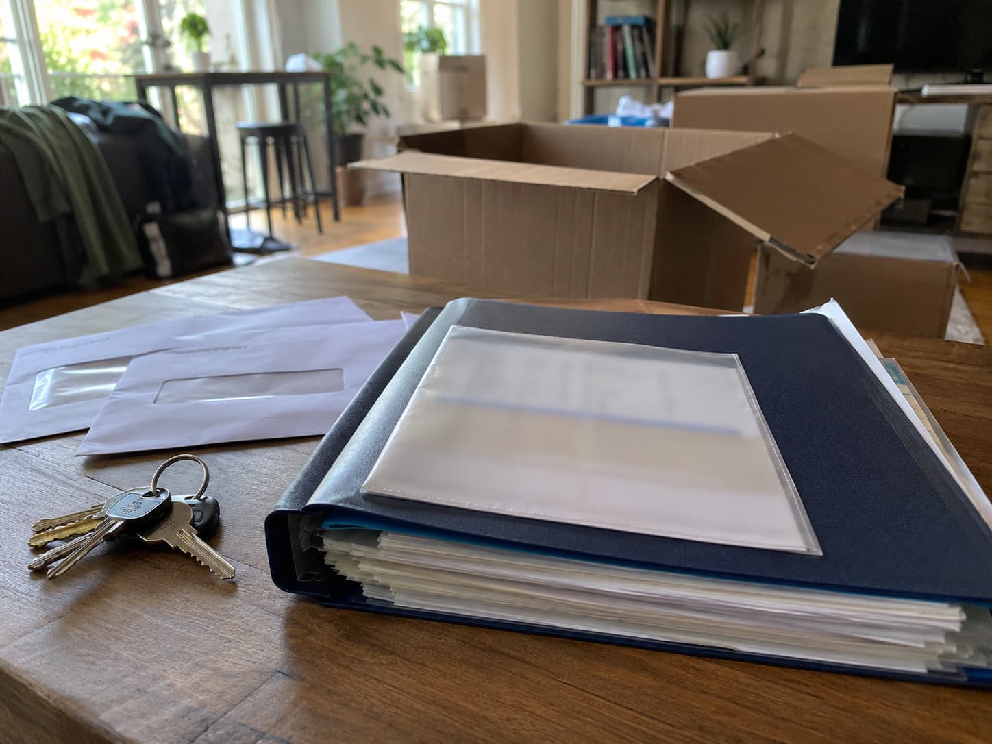 Organized folder with confirmations, keys, envelopes, and a few unpacked boxes.