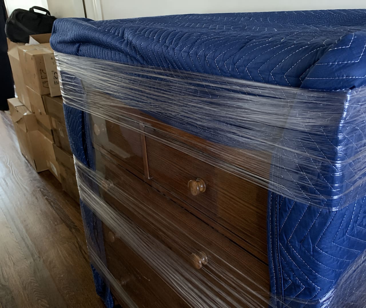 Moving blanket wrapped around wooden furniture to protect it during a move