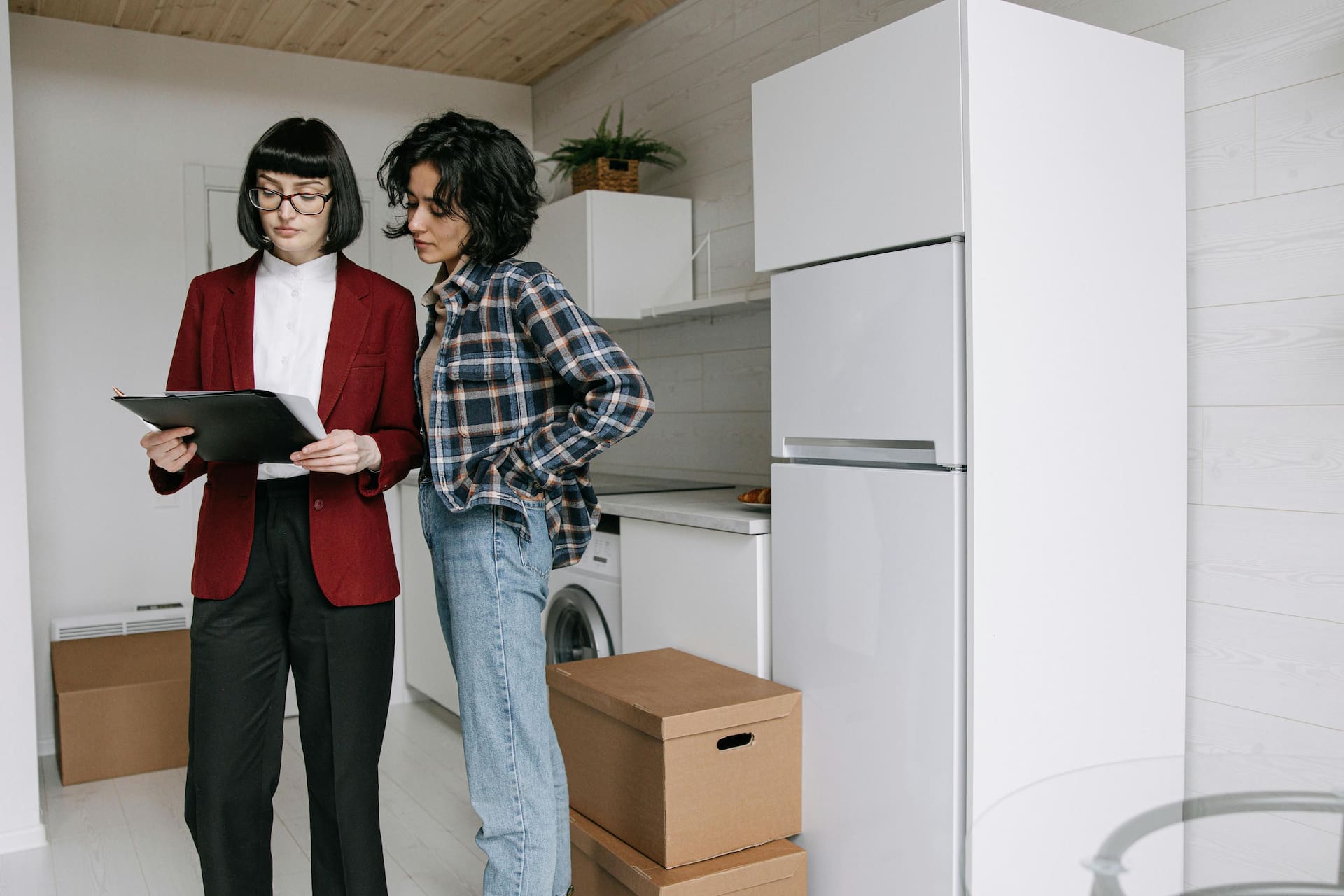 Couple reviewing moving paperwork beside a box